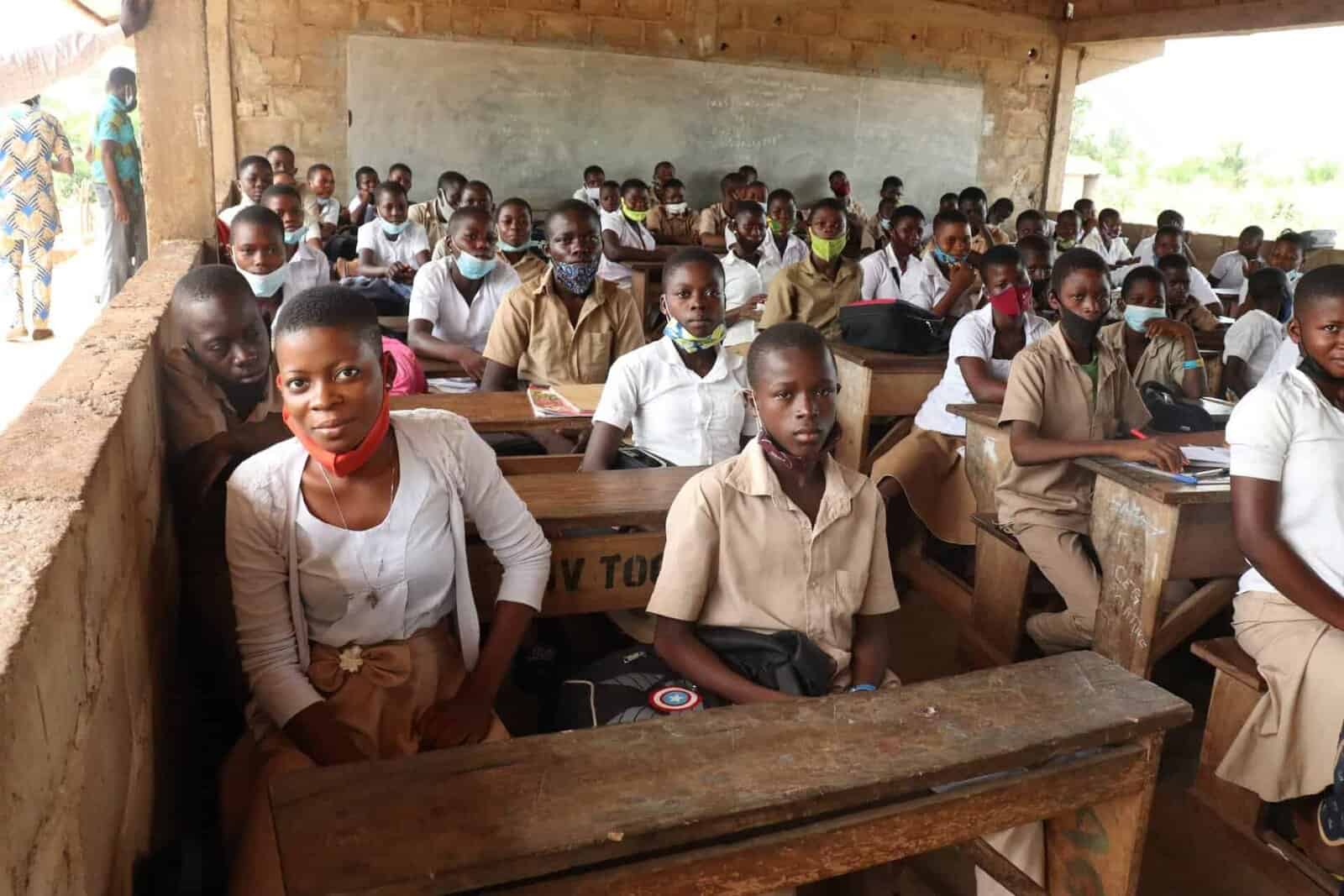 Projet-PAREC-II-Togo-Copyright-_-Arina-Bzhinaev-scaled Une élève devant un tableau noir en train de faire la lecture à ses camarades de classe