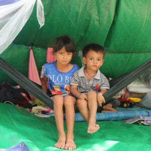 Des enfants sous une tente de fortune
