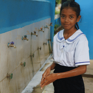 une fille devant les robinets des toilettes, cambodage
